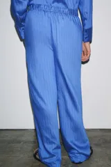 Pantalón de lyocell color azul con rayas verticales, tiro medio, cintura elástica ajustable con cordones y pierna ancha.