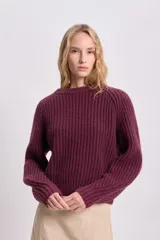 Sweater bordó de punto grueso con cuello redondo y mangas ranglan.