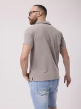 Chomba negra lisa de poliéster, algodón y core spun yarn, con cuello clásico y mangas cortas.