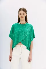 Remera lila con estampado de cachemir, de mangas cortas y cuello redondo. Tiene calce amplio y corte cruzado al frente.