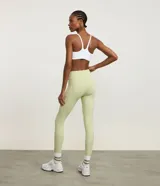 Legging deportivo de microfibra color verde claro, tiro alto, con moldería ajustada y bolsillo lateral funcional en el muslo.