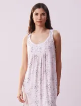 Camisón corto de tejido suave con estampado de rosas rosadas sobre fondo lila. Tiene escote redondo con detalle de puntilla blanca y botones.
