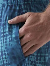 Short de baño color borgoña con estampado de hojas en tono sobre tono, cintura elástica con cordón ajustable y logo de la marca en la pierna.