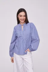 Blusa de mangas largas con diseño de rayas en tonos azules y blancos, con detalle de cuello y lazo en el frente.