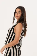 Chaleco tejido a rayas verticales en color negro y crudo, con escote en V y cierre frontal con ganchitos.