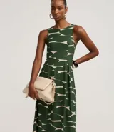 Vestido midi sin mangas, de corte al cuerpo y falda plisada, con cuello redondo y cierre por gota. Presenta un estampado abstracto en verde oscuro y beige.