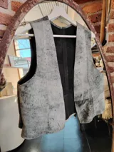 Chaleco de cuero gris con efecto desgastado y forro interior negro.