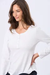 Remera manga larga lisa color beige, con cuello redondo y botones en la parte frontal.