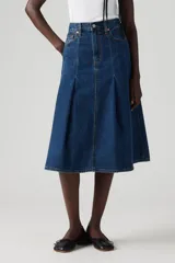 Falda midi de denim azul oscuro, con cintura alta, corte circular y pliegues en la parte delantera.