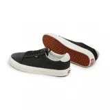Championes Vans Old Lux negros de cuero con suela blanca.
