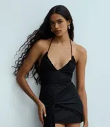 Body negro de tul con diseño halter y escote en V fruncido. Cuenta con tirantes finos que se atan al cuello y un calce ajustado.