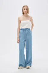 Pantalón de jean celeste, de corte ancho, con cintura elástica y cordón ajustable.