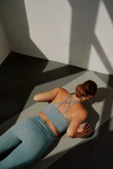Top deportivo celeste con espalda racerback y corte por debajo del busto.