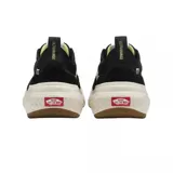 Zapatilla de lona negra con detalles en blanco, suela gruesa de goma y diseño clásico de Vans.