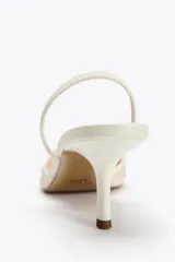 Zapato destalonado color blanco hueso, con tacón fino y punta fina. Capellada de mesh con bordados florales.