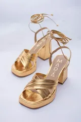 Sandalias rojas de cuero con plataforma y tiras para atar al tobillo.