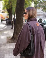 Camisa violeta oscuro con bolsillos con tapa ondulada y puños tableados.