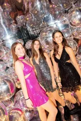 Vestido corto de lentejuelas color verde oliva, con escote en V, breteles finos cruzados en la espalda, cut-outs laterales y volado en el ruedo.