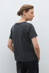 Remera de algodón color bordó, con cuello redondo, manga corta y detalle de ojalillos metálicos en el borde de las mangas.