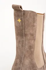 Bota Chelsea de gamuza color visón, con elásticos laterales y suela de goma color caramelo.