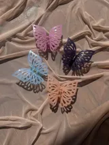 Broche para el pelo con forma de mariposa color lila, con diseño calado en las alas y agarre tipo pinza.