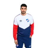 Buzo deportivo Umbro del Club Nacional de Football, modelo Ribbon. Diseño con corte en V en el pecho, mangas rojas con detalles de cinta tricolor en los hombros y logo de Umbro bordado en el pecho.
