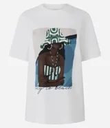 Remera blanca de algodón con estampa de una mujer con sombrero y traje de baño a rayas.