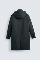 Parka larga color verde oscuro, con capucha desmontable, cuello solapa, bolsillos laterales y cierre frontal con cremallera oculta y botones a presión. Incluye chaleco interior acolchado desmontable.