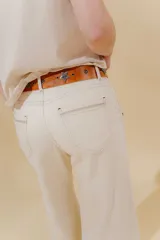 Pantalón de jean azul de pierna ancha y tiro medio, con cinco bolsillos y pespuntes a contratono.