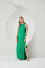 Vestido largo color verde, con corte recto y detalles de botones en el lateral.