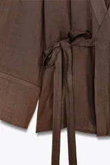 Kimono marrón de escote pico cruzado y manga larga amplia. Cierre con lazada interior y lateral.