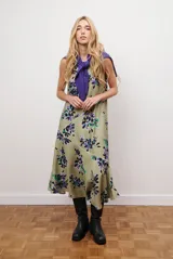 Vestido midi color beige con estampado de hojas en tonos violeta, verde y negro. Diseño sin mangas, con escote redondo y falda acampanada.