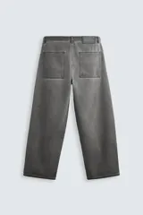 Pantalón de jean gris de corte amplio, estilo balloon fit, con cinco bolsillos, cierre frontal con cremallera y botón, y efecto de color lavado en toda la prenda.
