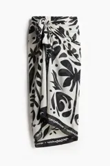 Pareo de playa con estampado de motivos tropicales en blanco y negro.