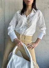 Camisa blanca de manga larga con bordado floral.
