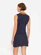 Musculosa roja de piqué de punto con cuello tipo polo marrón, sin mangas y calce cómodo. Incluye detalle bordado de vaquita de San Antonio en el frente.