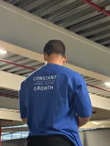 Remera gris de algodón, corte oversize, con estampado en la espalda con la frase "CONSTANT GROWTH" y la leyenda "Limited Edition - Only 10 Units".