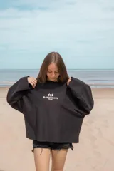 Buzo negro de corte amplio con estampado frontal de la marca 'Classy Waves' en color blanco. Es de mangas largas y cuello redondo. Es reversible y se puede usar de ambos lados.