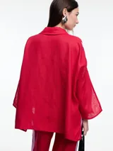 Camisa de lino color negro con silueta amplia y mangas 3/4. Diseño con tiras de color blanco en contraste en la cartera, mangas y cuerpo. Tiene tajos laterales y ruedo irregular en el frente.