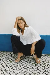 Camisa corta blanca con bordados perforados, cuello solapa, escote pico y manga larga abullonada.