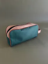 Neceser de lona verde con detalles en cuero color beige y etiqueta con logo de la marca Sierra Mora.