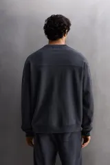 Sudadera de entrenamiento color gris claro, de corte relaxed fit, confeccionada en tejido de algodón con interior de rizo. Tiene cuello redondo, manga larga y acabados en rib.