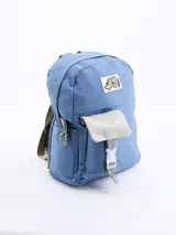 Mochila celeste con bolsillo frontal gris con cierre de hebilla y parche con diseño de dinosaurio.