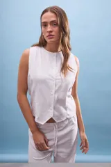 Musculosa blanca de lino con cuello redondo y abotonadura frontal.