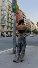Pantalón cargo oversize de jean con efecto lavado, múltiples bolsillos funcionales y detalles metálicos en bronce.