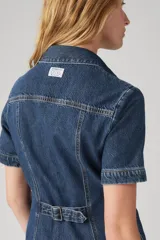 Vestido camisero corto de denim azul oscuro, con cuello clásico, mangas cortas y cierre frontal con botones.