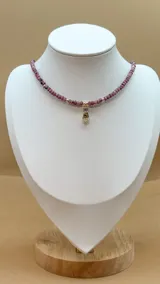 Collar de cinco hilos de cuentas facetadas de jade de Malasia color borgoña, con cuentas doradas y dijes colgantes dorados con incrustaciones de strass: estrella, espiral, mano de Fátima, luna creciente y esqueleto de pez.