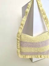 Cartera tejida a crochet con hilo 100% de algodón, con diseño a rayas y volados bordeando la cartera extendiéndose hacia la manija.