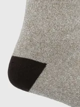 Calcetines de caña media color beige con talón y puntera en marrón oscuro. Tejido grueso.