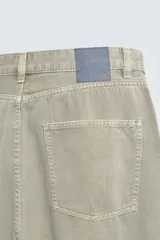 Pantalón de jean blanco, corte holgado y amplio en toda la pierna, tiro medio, tejido ligero, cinco bolsillos, efecto lavado y cierre frontal con cremallera y botón.